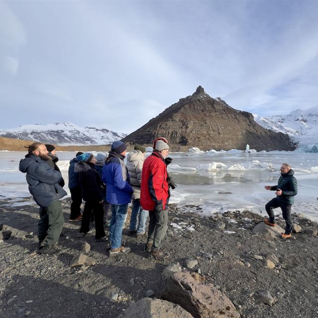 Thomas Hüttmann auf Gletscher in Island mit Gruppe im Gespräch