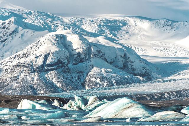 Das Foto zeigt Gletscher mit gefrorenen Gletscherlagune und unterschiedlichsten Blautönen.