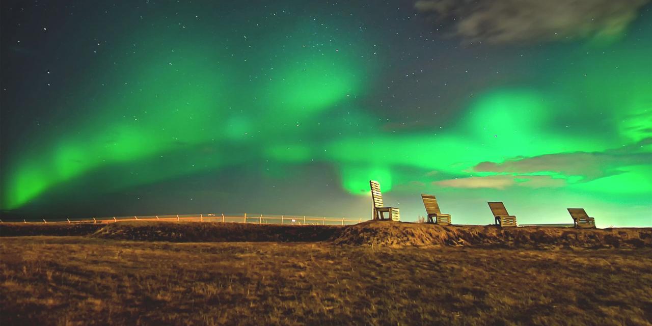 Nordlichter über vier Liegestühlen in Island